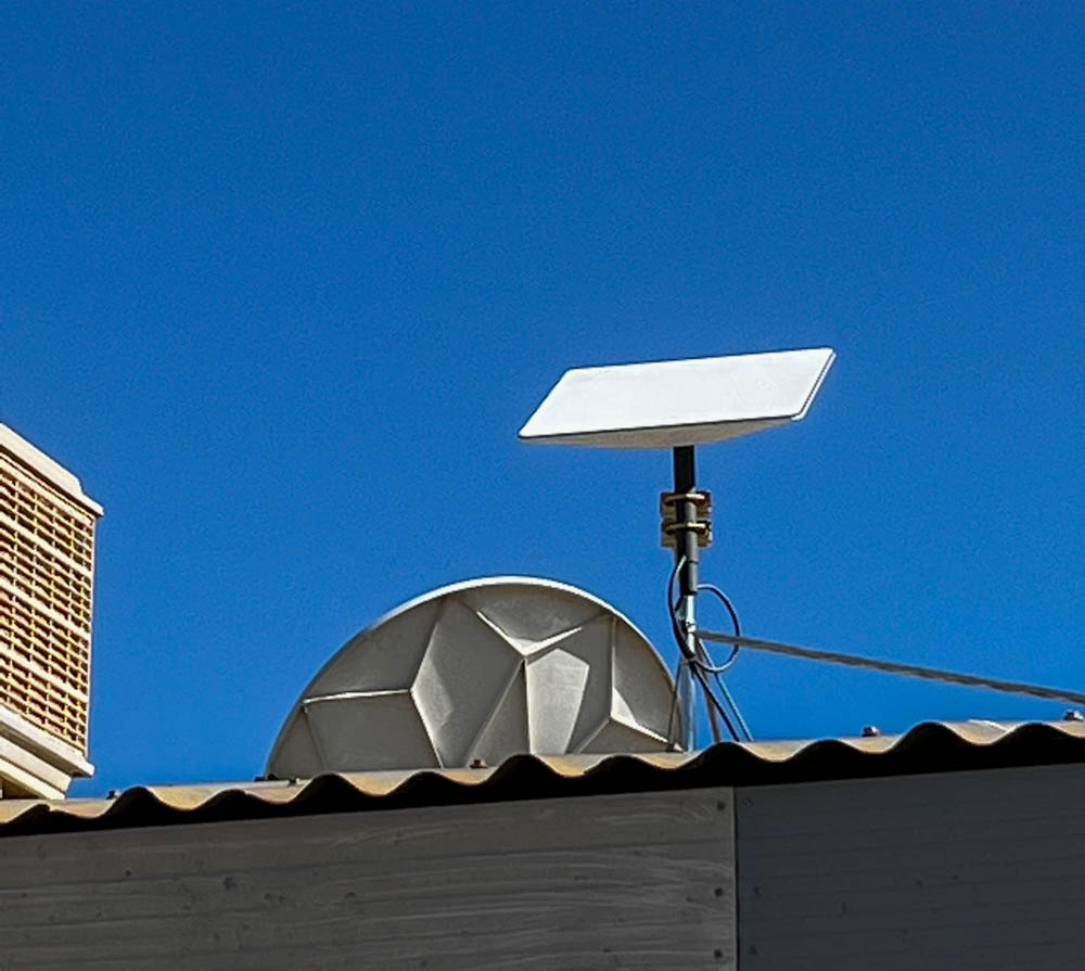 A Starlink receiving dish on an office roof.